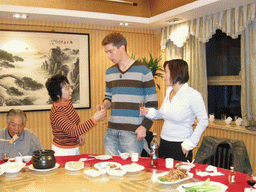 Tim, Miaomiao and Miaomiao`s aunt and grandfather having drinks in a restaurant in the city center