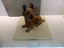 Red glazed pottery crouching dog, in the temporary exhibition building of the Henan Museum, with explanation