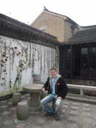 Tim at a table in a garden of a house at the Zhouzhuang Water Town