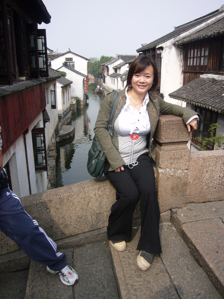 Miaomiao in front of a canal with boats at the Zhouzhuang Water Town