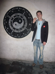 Tim eating a lollipop with a yin and yang sign at the Zhouzhuang Water Town