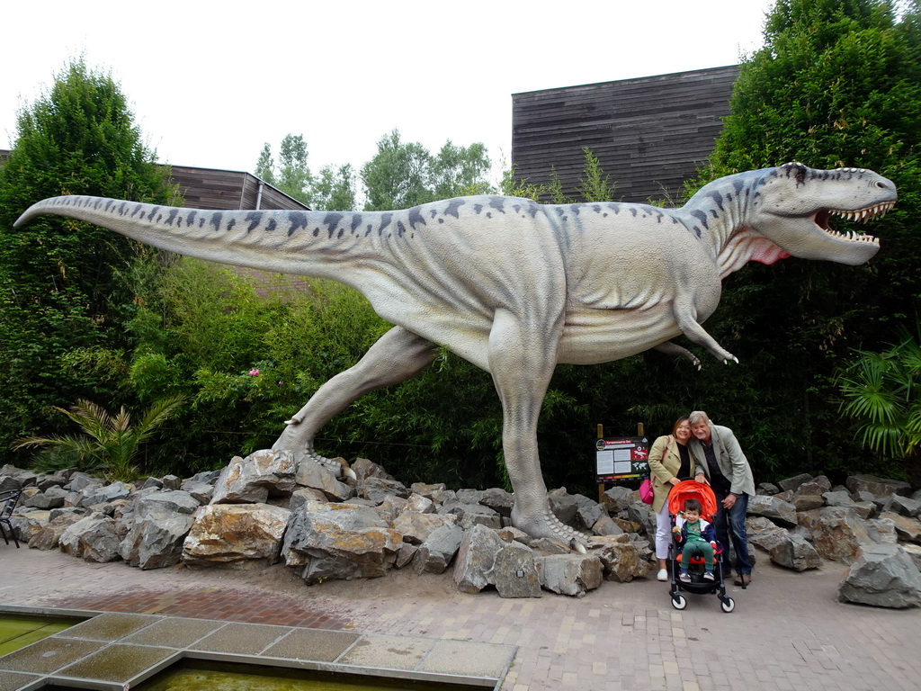 Miaomiao, Max and Max`s grandfather in front of the Tyrannosaurus Rex statue at the main square of Dinoland Zwolle, with explanation