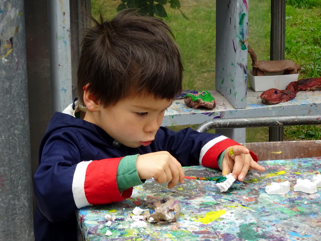 Max painting a Dinosaur statuette made from clay at the PaleoLab at Dinoland Zwolle