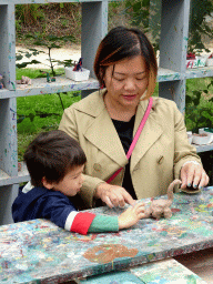 Miaomiao and Max making Dinosaur statuettes from clay at the PaleoLab at Dinoland Zwolle