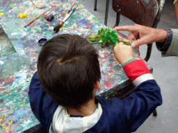 Max painting a Dinosaur statuette made from clay at the PaleoLab at Dinoland Zwolle