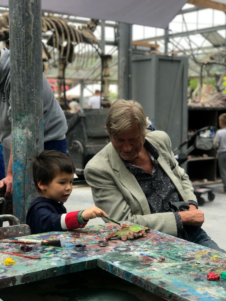 Max and his grandfather painting a Dinosaur statuette made from clay at the PaleoLab at Dinoland Zwolle
