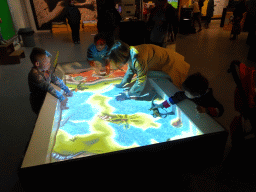 Miaomiao and Max playing with the virtual sand table at the T-Rexpedition at Dinoland Zwolle