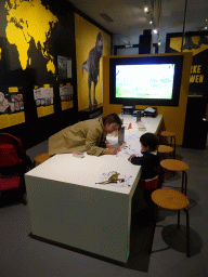 Miaomiao and Max colouring a drawing to create a virtual dinosaur at the T-Rexpedition at Dinoland Zwolle