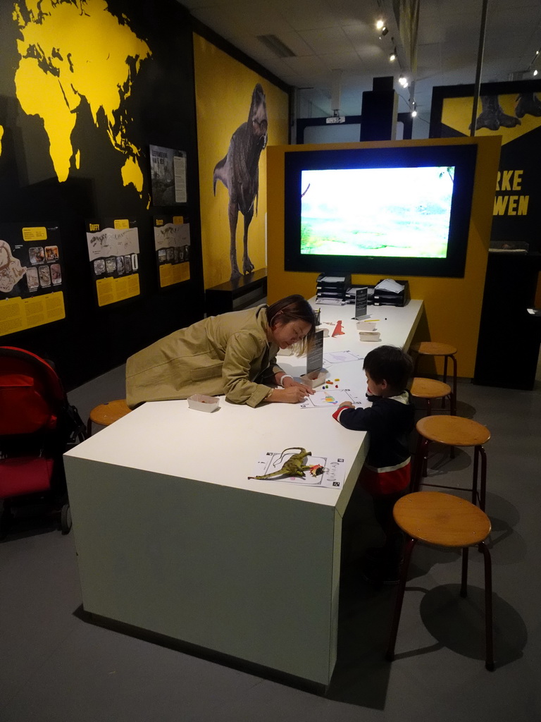 Miaomiao and Max colouring a drawing to create a virtual dinosaur at the T-Rexpedition at Dinoland Zwolle